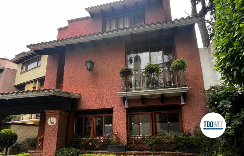 Fachada de una casa de tres niveles en color terracota con balcón y jardín al frente, ubicada en Altamirano 50, Tizapán San Ángel.